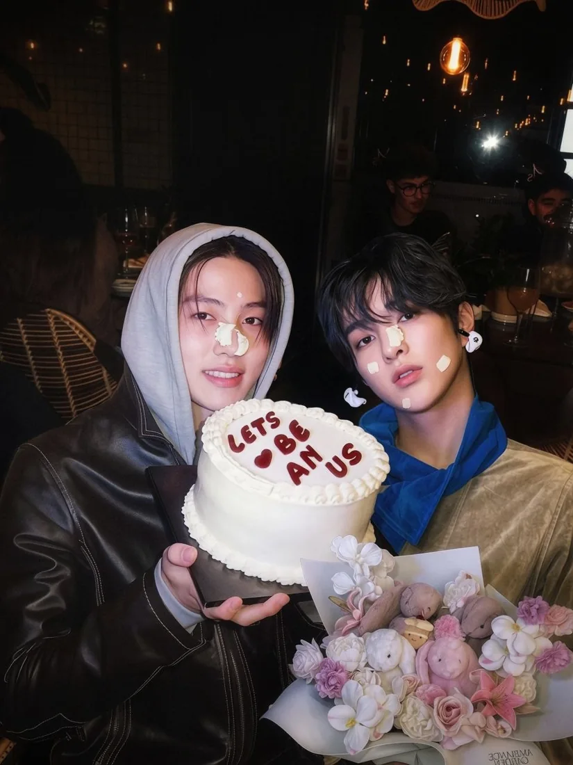 Cad and Anelka holding a cake and flowers